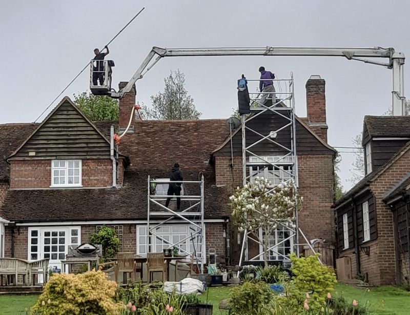 The Roof Moss Cleaners using cherry picker and scaffolding to clean roof safely and professionally in Crawley, West Sussex